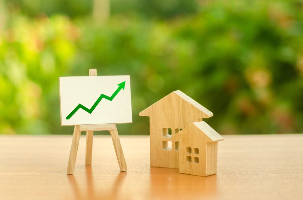 Two wooden houses and stand with green up arrow